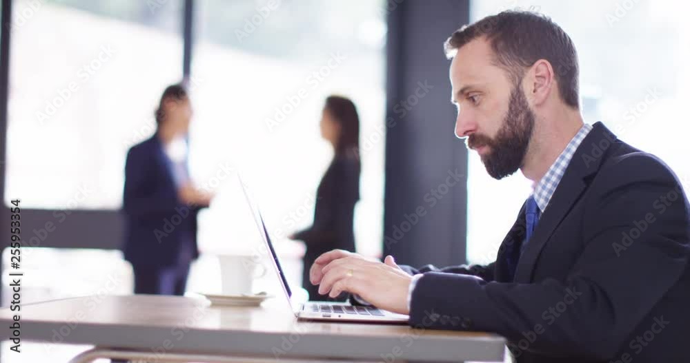 4K Bored office worker surfing the web, with female colleagues in background 4K Bored office worker surfing the web, with female colleagues in background