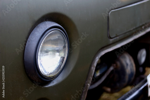 Glass headlight of an old retro russian truck SUV all-terrain khaki colour © Наталия Чубакова