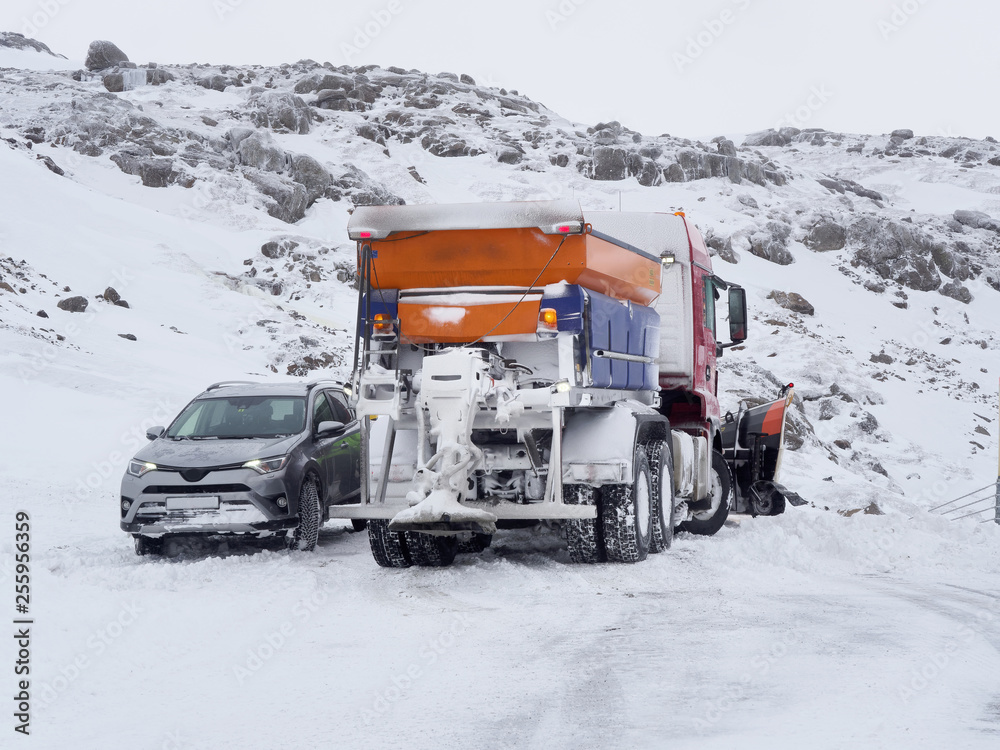 car rescued by a snowplow, Iceland mountain road in winter car rescued by a snowplow, Iceland mountain road in winter