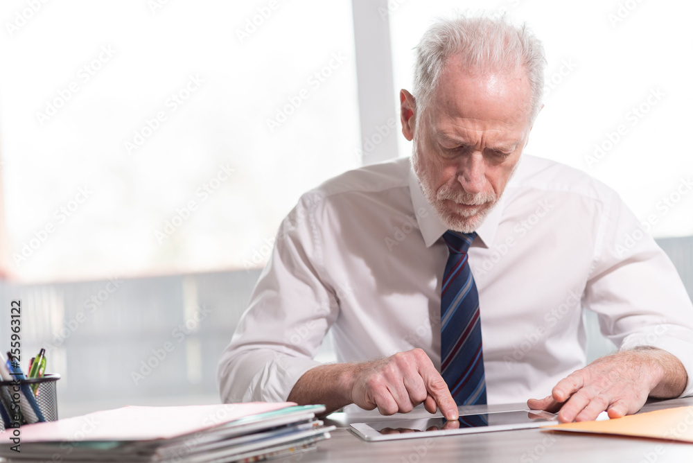 Portrait of senior businessman working on tablet Portrait of senior businessman working on tablet