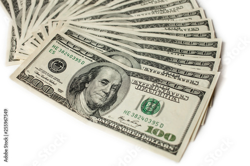 fan of hundred dollar bills isolated on white background with focus on first bill