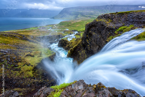 Dynjandi waterfall, Iceland, amazing landscape. Stunning view of falling water in the canyon from the top to the Dynjandisvogur bay and Arnarfjordur fjord, Westfjords of Iceland, travel background