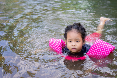 Fototapeta Naklejka Na Ścianę i Meble -  little asian girl swimming in the river