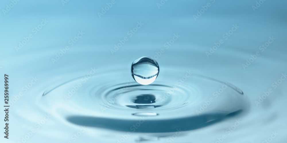 a drop of water close-up drips into the water, forming circles
