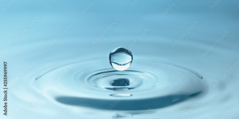 a drop of water close-up drips into the water, forming circles a drop of water close-up drips into the water, forming circles