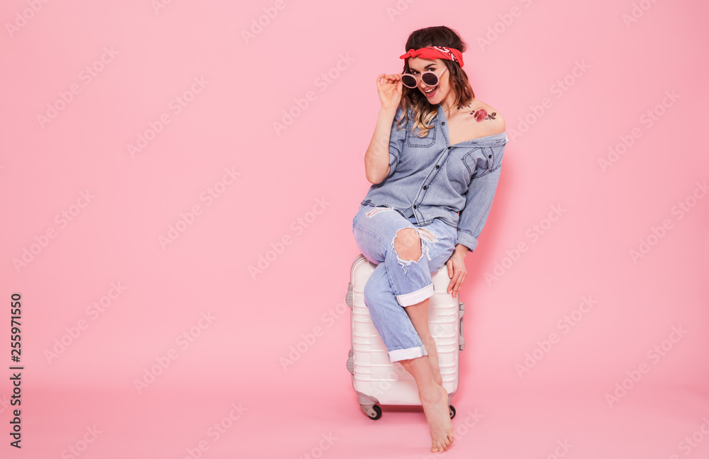 Portrait of a girl with a suitcase on a pink background Portrait of a girl with a suitcase on a pink background