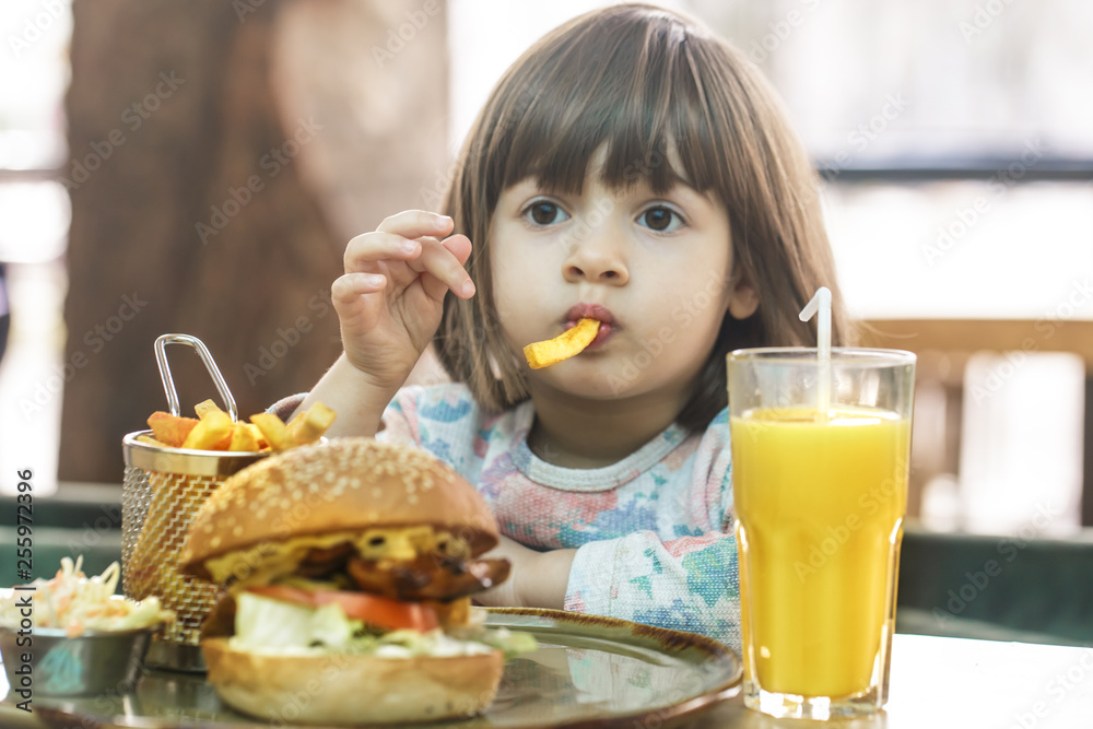 Little girl eats in a fast food cafe Little girl eats in a fast food cafe