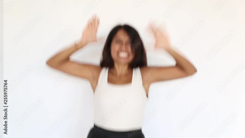 Pretty young latin woman is dancing and having fun standing on white background. Pretty young latin woman is dancing and having fun standing on white background.