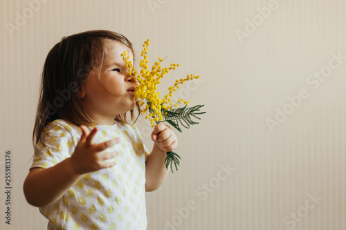 Canvastavla Child smelling a mimosa