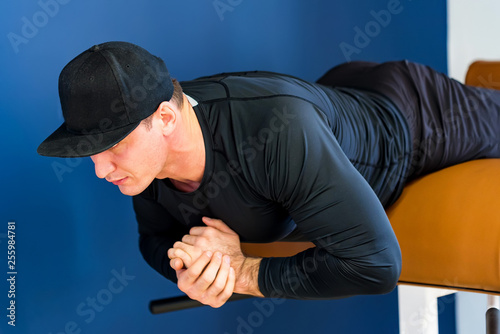 Portrait of male athlete doing abs exercise in gym