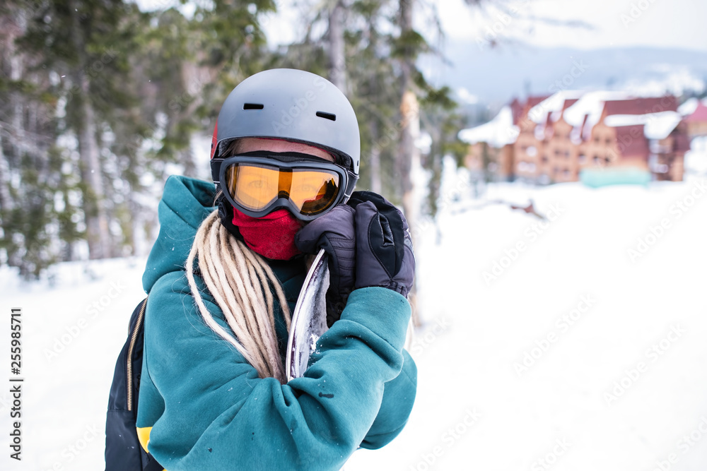 Portrait of a female snowboarder in outdoor equipment.