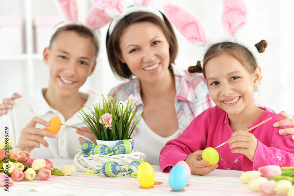 Portrait of family painting traditional Easter eggs in different colors at home Portrait of family painting traditional Easter eggs in different colors at home