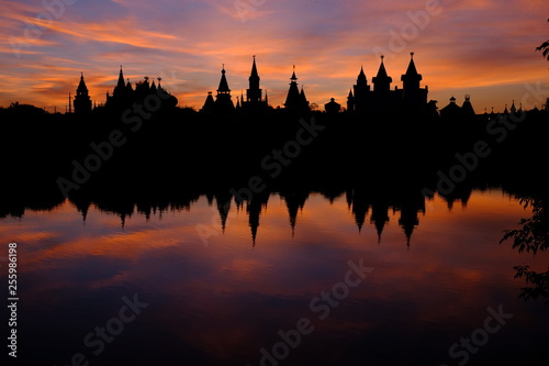 Silhouette of the castle and its reflection in the lake at sunset