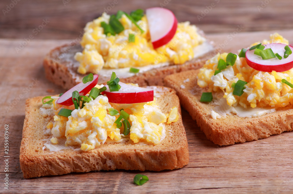 Toasted bread with scrambled eggs with fresh chives and radish for breakfast Toasted bread with scrambled eggs with fresh chives and radish for breakfast