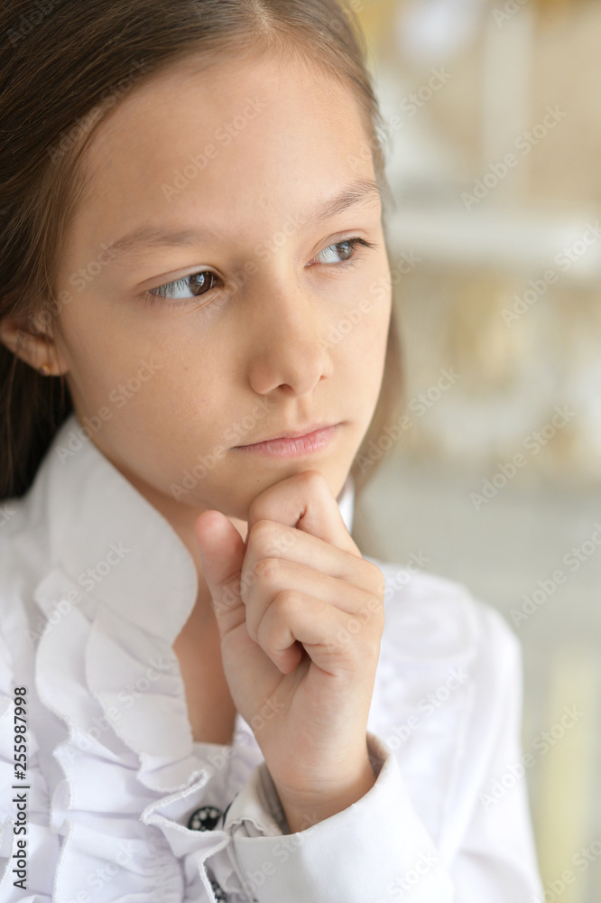 Close-up portrait of little girl in white blouse posing
