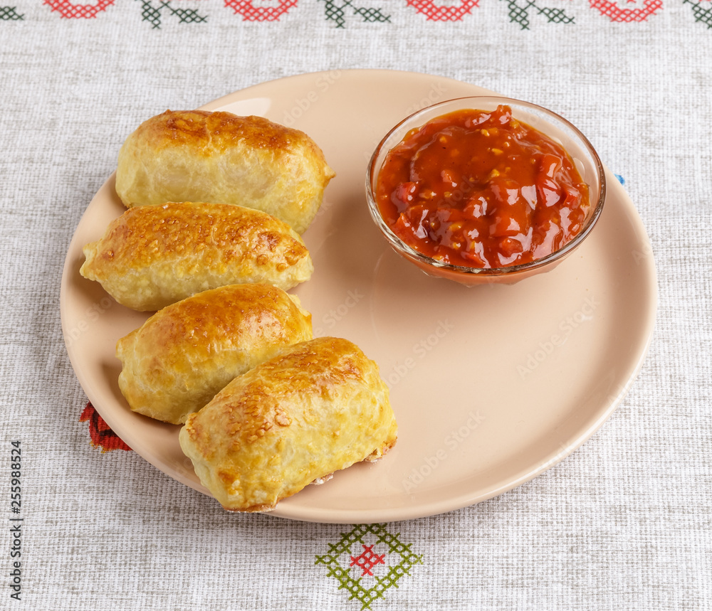 Pastries and sauce on a plate on a napkin.