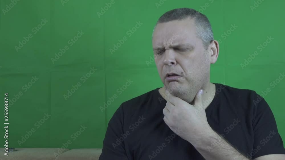 A man who has the flu. The man has a headache, he rubs his temples A man who has the flu. The man has a headache, he rubs his temples