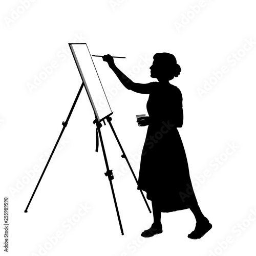 Silhouette of a young woman who paints a picture on the easel