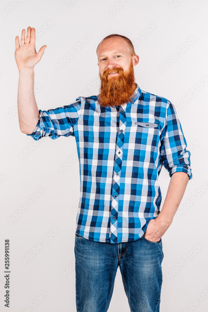 Bearded man with welcome gesture and looking at camera, standing over gray background. Bearded man with welcome gesture and looking at camera, standing over gray background.