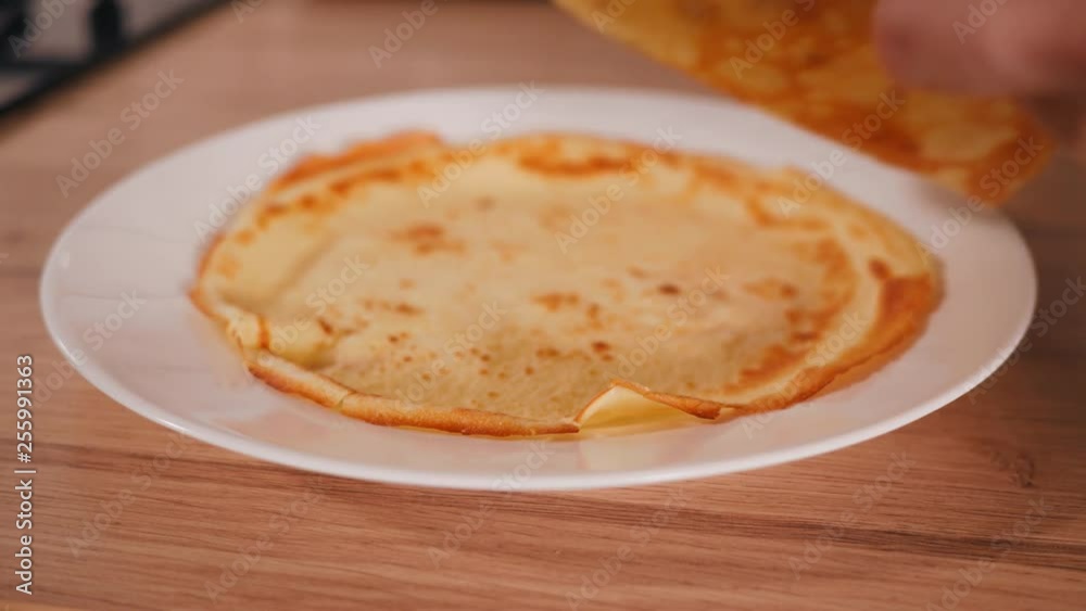 Laying out just cooked pancakes on a white plate Laying out just cooked pancakes on a white plate