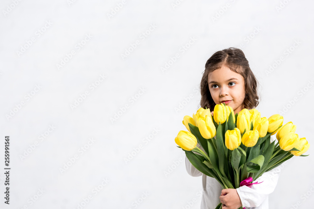 Inspired brunette woman touching hair and looking away with smile isolated on grey Inspired brunette woman touching hair and looking away with smile isolated on grey