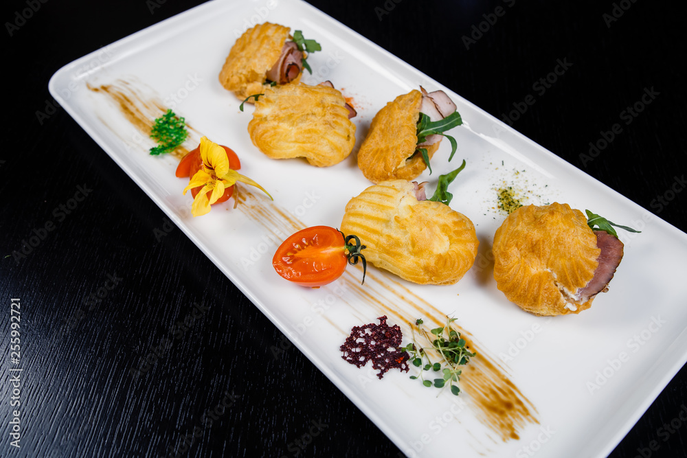 Mousse of cheese with bacon in eclair, covered with green and tomato cherry Mousse of cheese with bacon in eclair, covered with green and tomato cherry