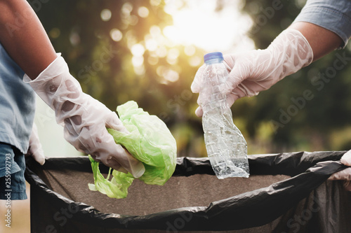 woman hand picking up garbage plastic for cleaning at park