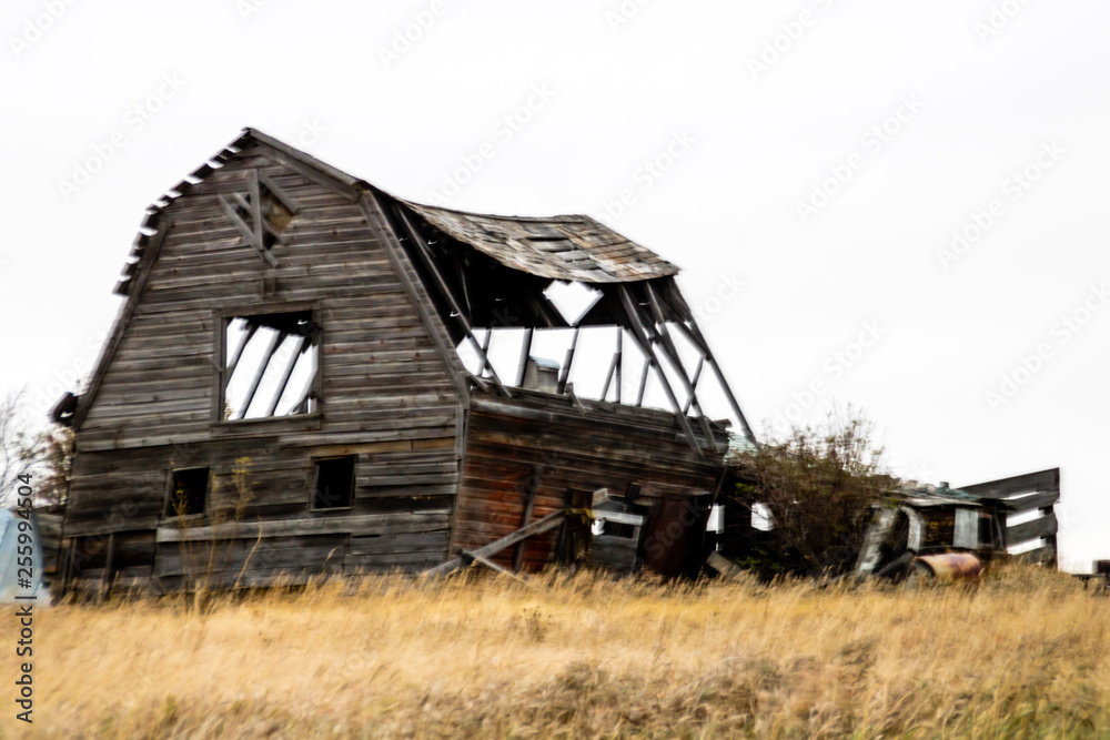 Fototapeta premium Abondoned farm buildings dot the landscape along HWY 4, Saskatchewan, Canada