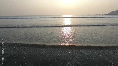 The person captures the sunset on Shrivardhan Beach while the beautiful waves kisses his feet. photo