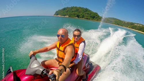 Man with a girl riding a jet ski on the sea. People ride a jet ski. Phuket, Thailand. 