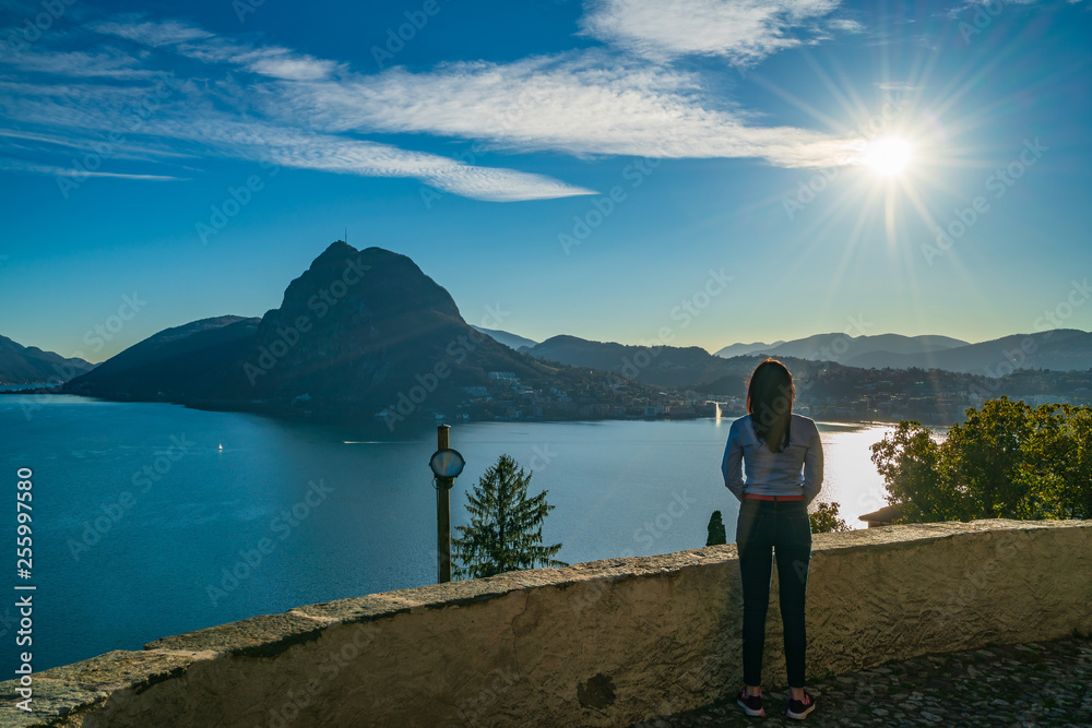 Young girl enjoying view on lake Lugano and mountain San Salvatore, Switzerland, Europe, Ticino Young girl enjoying view on lake Lugano and mountain San Salvatore, Switzerland, Europe, Ticino