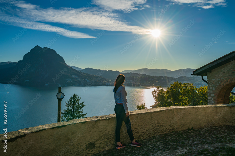 Young girl enjoying view on lake Lugano and mountain San Salvatore, Switzerland, Europe, Ticino