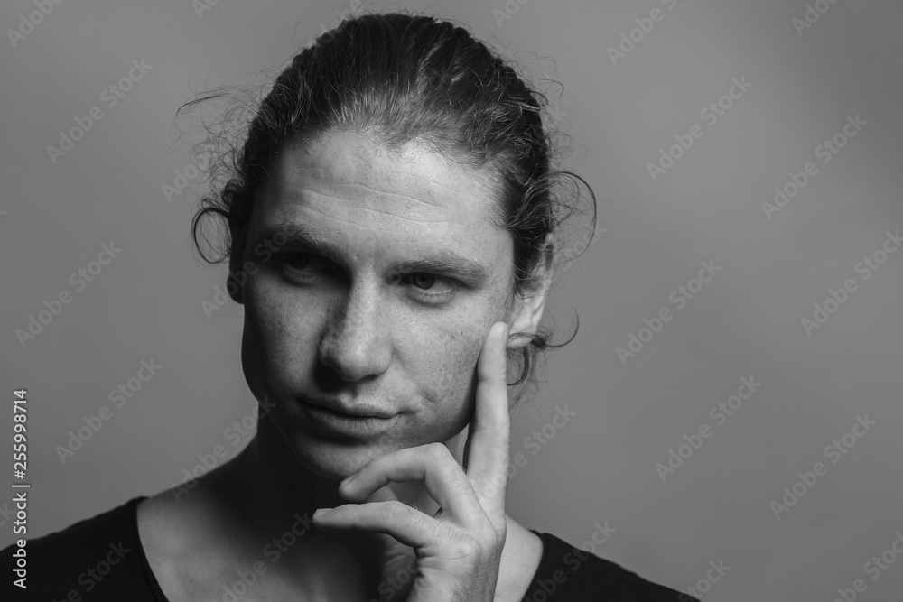 Portrait of a handsome long-haired man with drawn hair and freckles wearing a black T-shirt Portrait of a handsome long-haired man with drawn hair and freckles wearing a black T-shirt