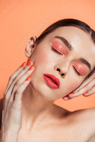 beautiful stylish young woman with eyes closed posing isolated on coral