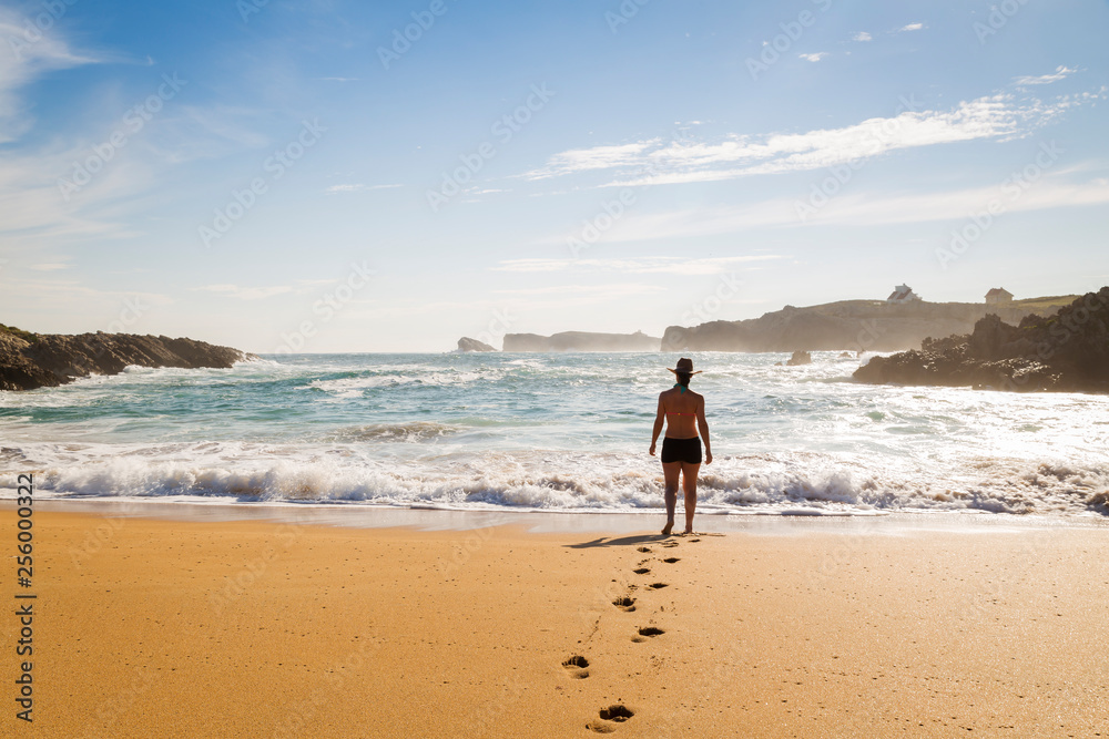 woman walking on the sand of a beautiful beach woman walking on the sand of a beautiful beach