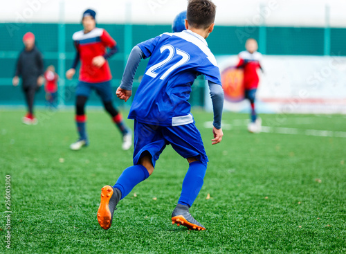 Football training soccer for kids. Boy runs kicks dribbles soccer balls. Young footballers dribble and kick football ball in game. Training, active lifestyle, sport, children activity concept 