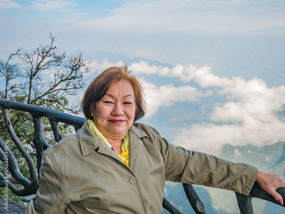 Portrait photo of beautiful asian senior women with beautiful view on Tianmen mountain and clear Sky in zhangjiajie city China.Tianmen mountain the travel destination of Hunan zhangjiajie city China Portrait photo of beautiful asian senior women with beautiful view on Tianmen mountain and clear Sky in zhangjiajie city China.Tianmen mountain the travel destination of Hunan zhangjiajie city China