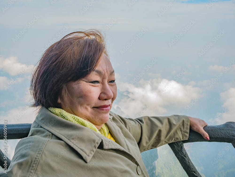 Portrait photo of beautiful asian senior women with beautiful view on Tianmen mountain and clear Sky in zhangjiajie city China.Tianmen mountain the travel destination of Hunan zhangjiajie city China Portrait photo of beautiful asian senior women with beautiful view on Tianmen mountain and clear Sky in zhangjiajie city China.Tianmen mountain the travel destination of Hunan zhangjiajie city China