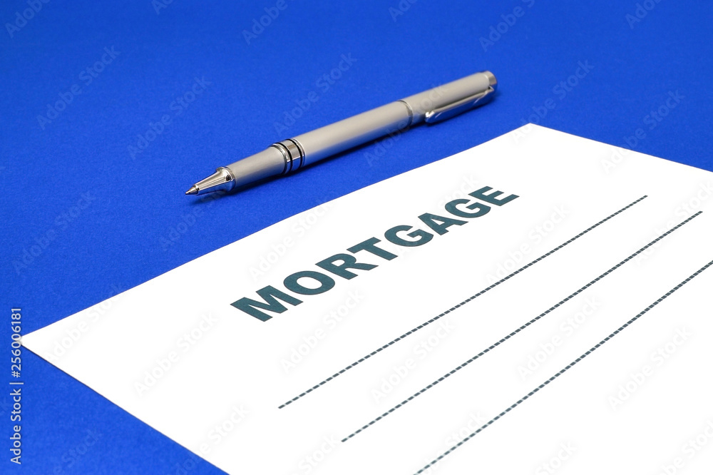 Mortgage with a pen on a blue background. Mortgage with a pen on a blue background.