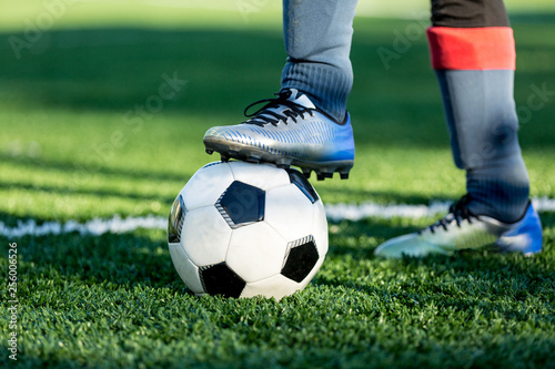 Boy puts his leg on ball on soccer field. Training, active lifestyle, sport, children activity concept 