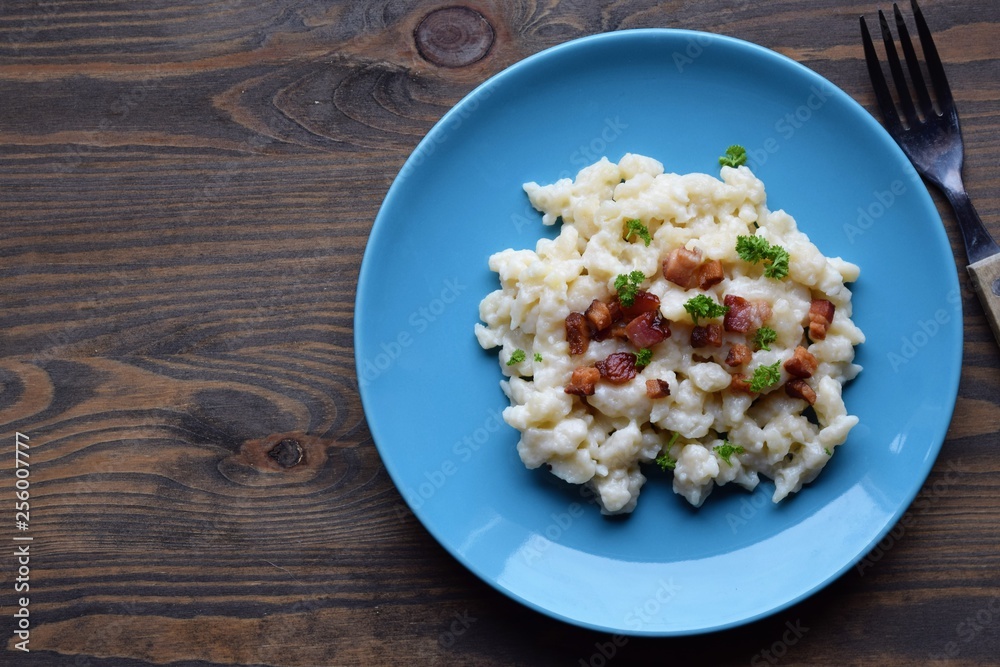 Slovak traditional potato gnocchi with sheep cheese and bacon,wooden table Slovak traditional potato gnocchi with sheep cheese and bacon,wooden table