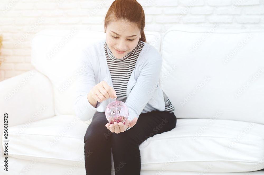 Beautiful Asian woman is smiling.Pink piggy piggy bank in Asian women hand.Women are happy in saving. Beautiful Asian woman is smiling.Pink piggy piggy bank in Asian women hand.Women are happy in saving.