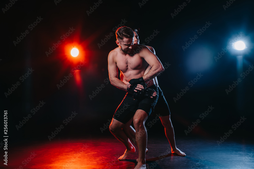 strong mma fighter doing clinch to another sportsman behind back