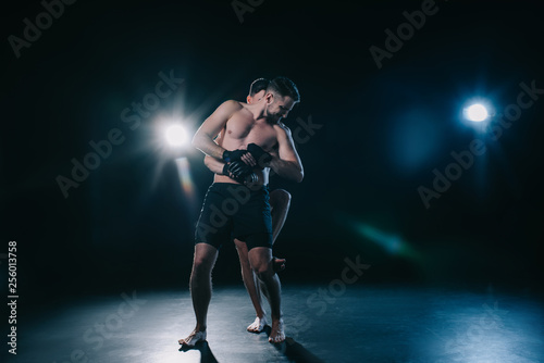 Fototapeta Naklejka Na Ścianę i Meble -  mma fighter doing clinch to another sportsman behind back during training