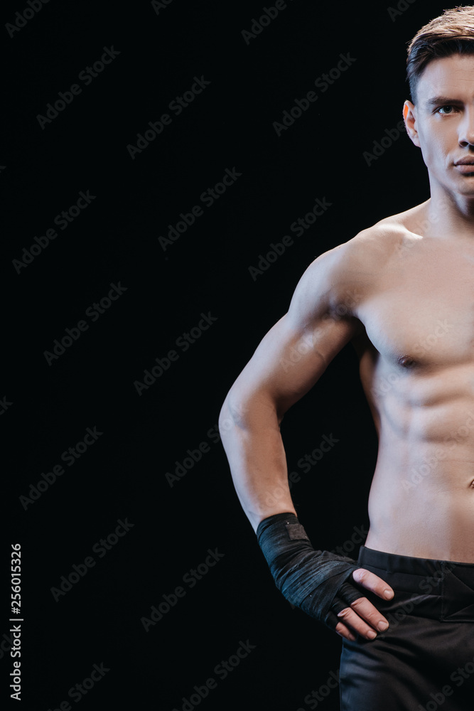 Fototapeta premium partial view of muscular sportive boxer in bandages isolated on black