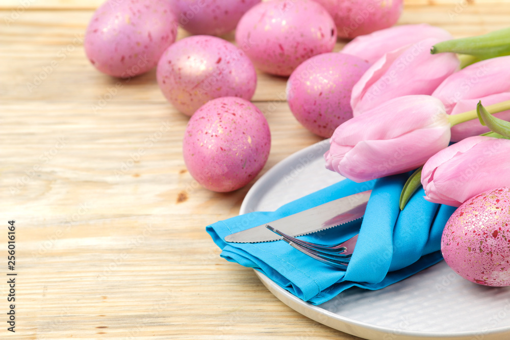 Easter. Easter table setting. Pink Easter eggs and flowers tulips on a natural wooden table. Happy easter. holidays.