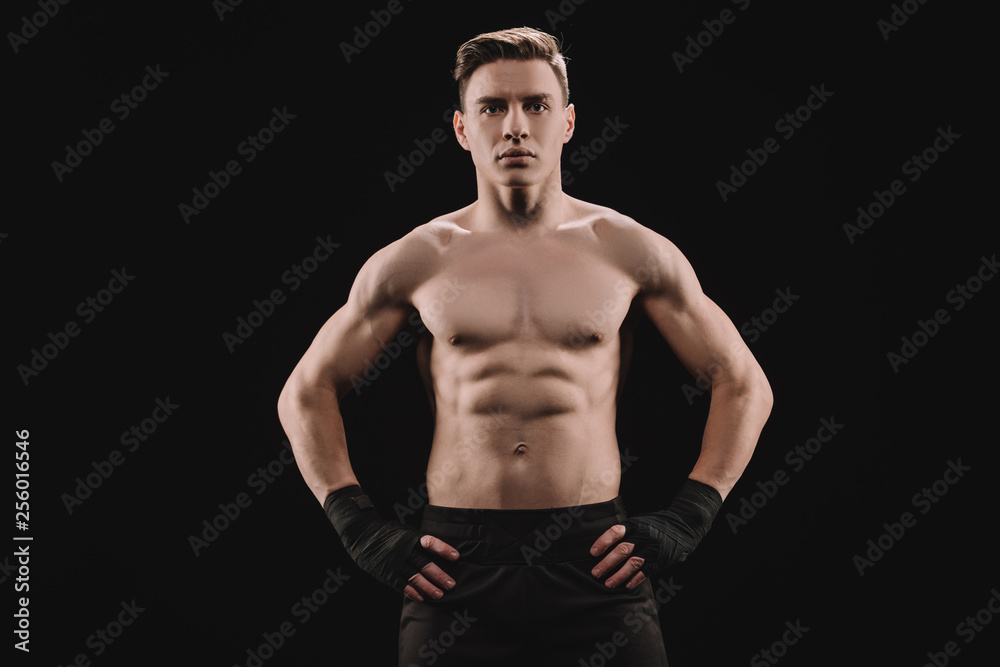 strong muscular sportsman looking at camera with hands on hips isolated on black strong muscular sportsman looking at camera with hands on hips isolated on black