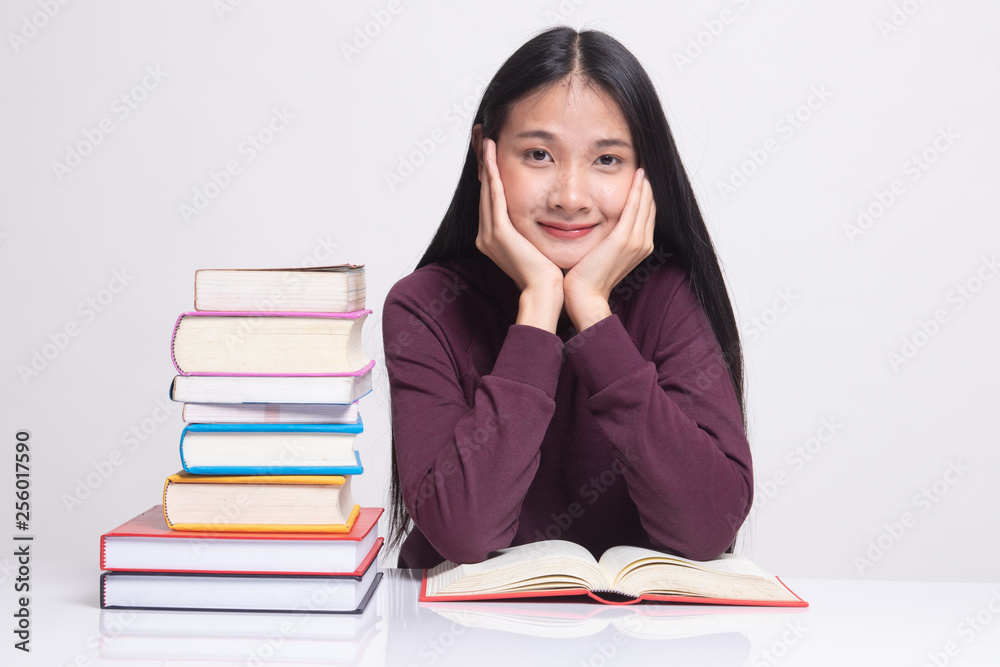 Young Asian woman read a book with books on table. Young Asian woman read a book with books on table.