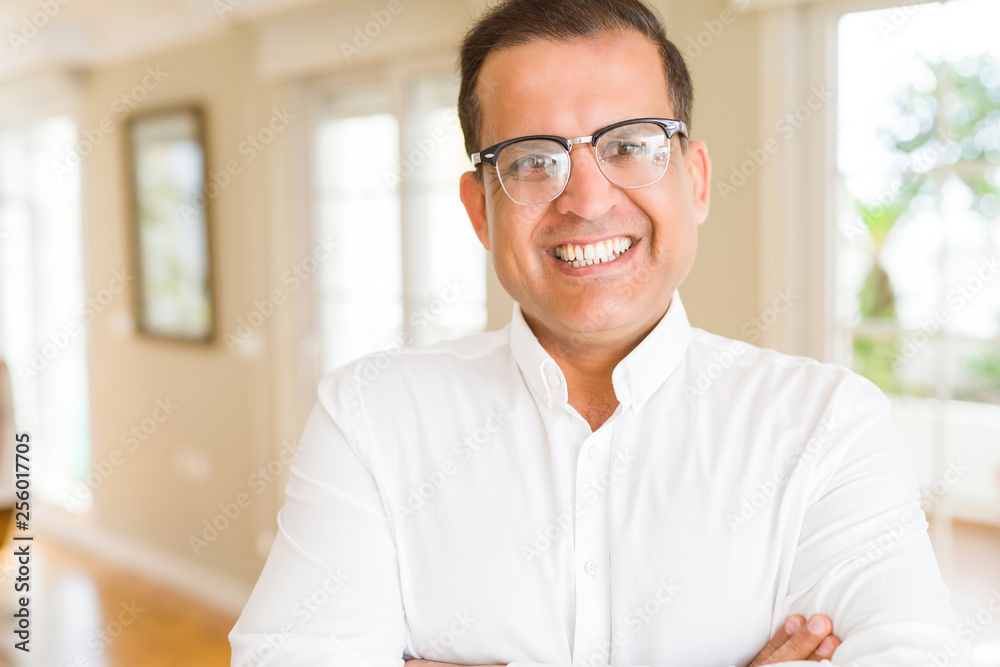 Middle age man wearing glasses smiling to the camera at home Middle age man wearing glasses smiling to the camera at home