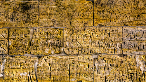 Wall with limestone bricks with illegible engravings that have been written by people with the passage of time, the Proosdij park in Meerssen south Limburg in the Netherlands Holland